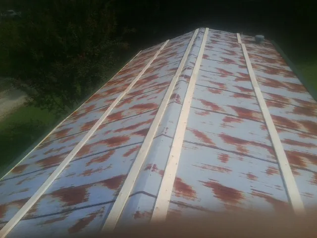 Rusted metal roof panels with new wood purlins before replacement — Storm Damage Roof Repair in Bailey by Roofing Brothers