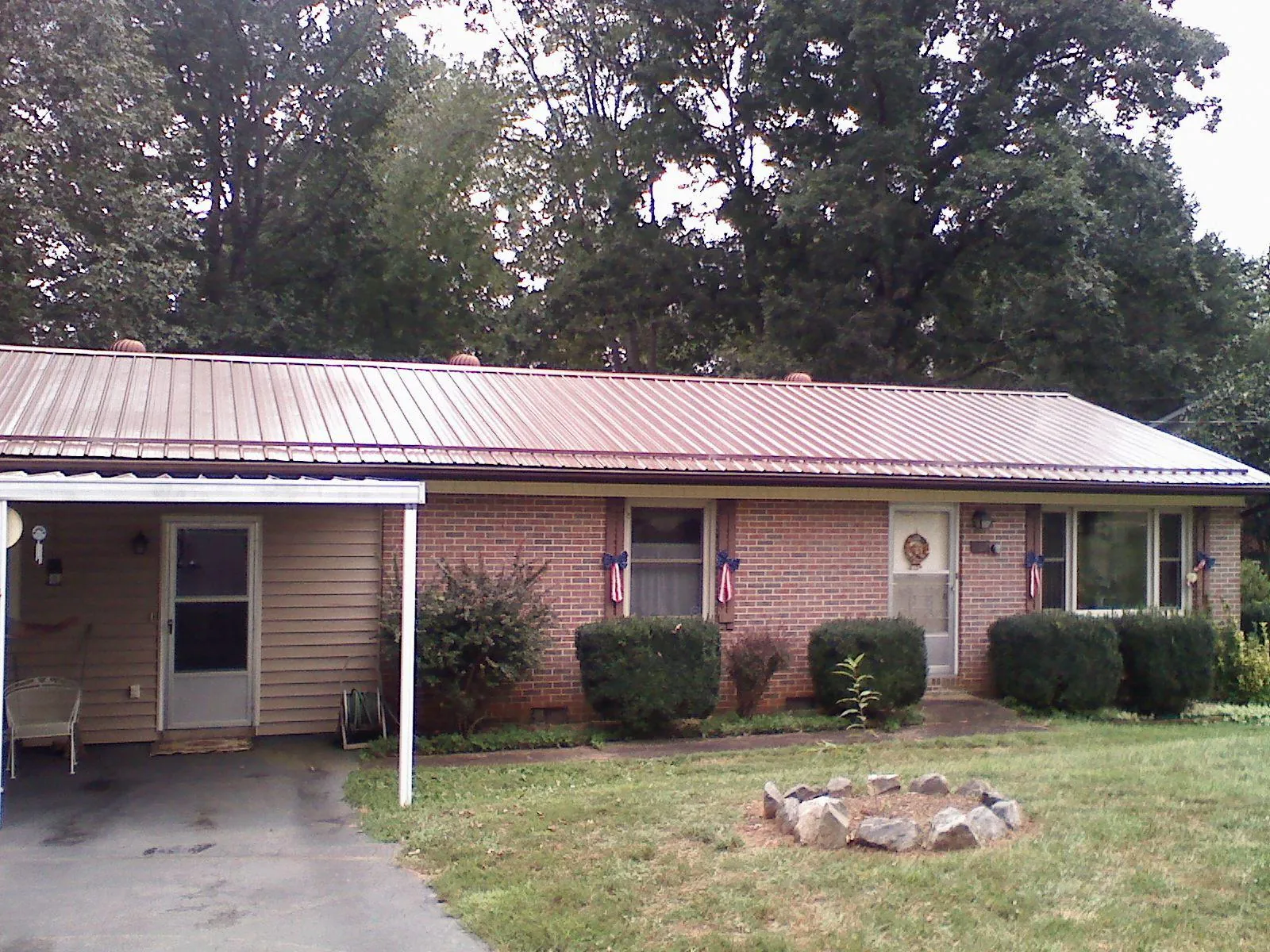 Bronze metal roof and carport on a brick ranch home — Roof Repair work by our crew in Bailey